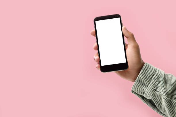 istock Man holding smartphone with blank screen on pink background, closeup. Mockup for design 2157876051