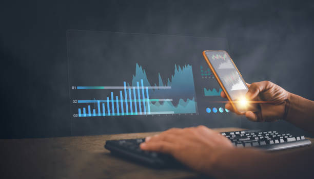 istock Investor using smartphone app analyzing financial data stock market with virtual interface screen, Business analytics and data management system on computer virtual screen, strategy for finance. 2157877022