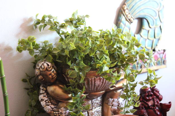 small figure of an angel lying and dreaming between violet and green plant