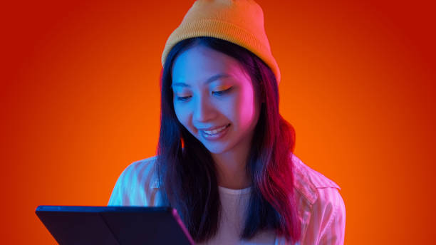 istock Internet surfing reading tablet woman neon light 2157883899