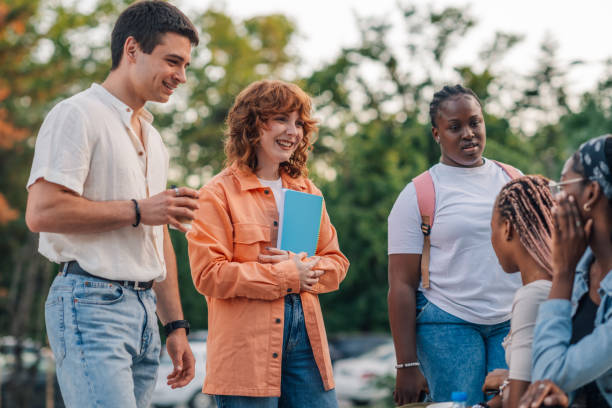 istock Happy ginger college girl chatting with her diverse classmates on break 2157883998