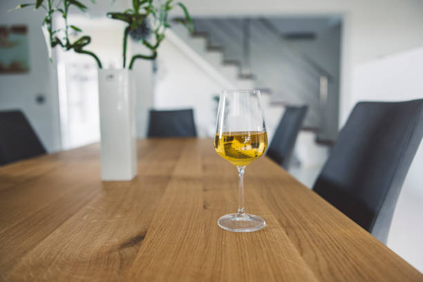 istock Glass of white wine on wooden dining table 2157885160