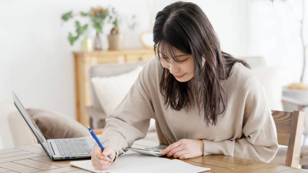 istock A woman calculating with a calculator and taking notes 2157888716