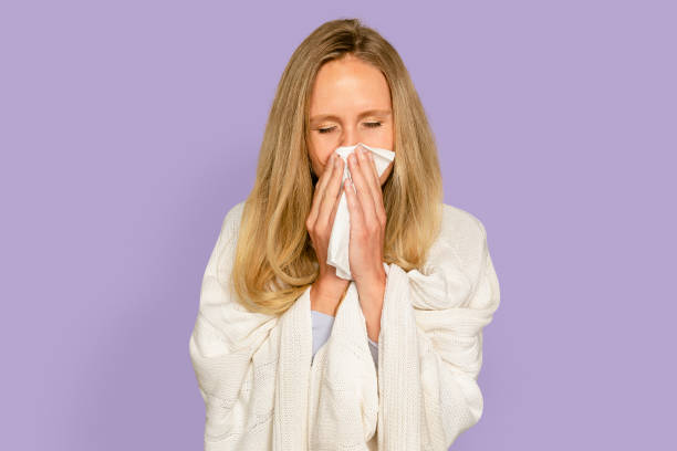 istock Woman blowing nose with blanket covering her 2157892809