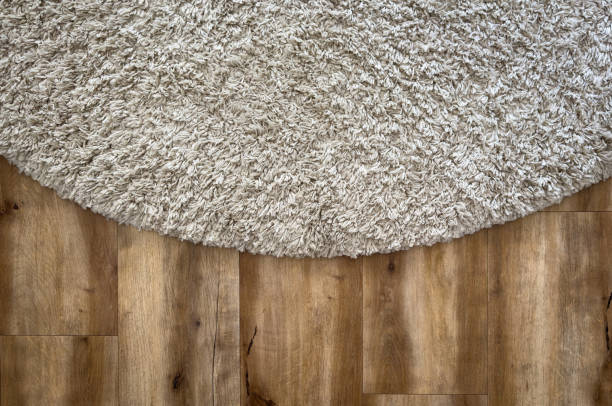 Beige coloured shag pile floor rug texture on wooden floor boards