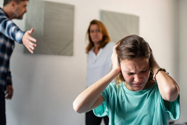istock Young girl blocking her ears due to her parents arguing 2157898928