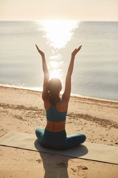 Woman Practicing Yoga on Beach at Sunrise
