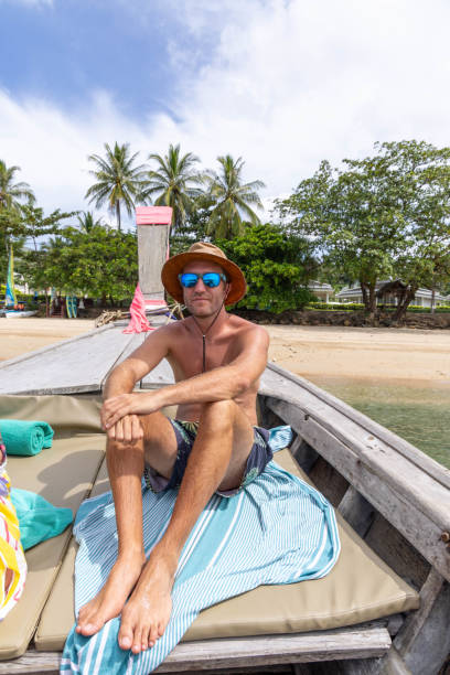 istock Man Enjoying Leisure Time on Boat at Tropical Beach 2157906762