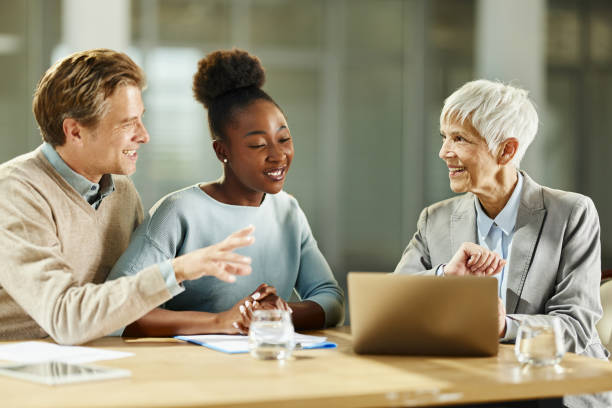 istock Happy diverse couple using laptop with their agent in the office. 2157907586