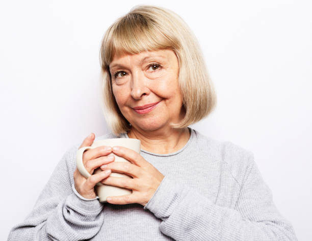 istock Old excited lady smiling laughing, holding cup drinking coffee, tea, beverage on white background 2157908258
