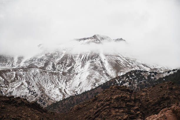 Atlas of Morocco with clouds at the top on a cloudy day. Snowy mountain