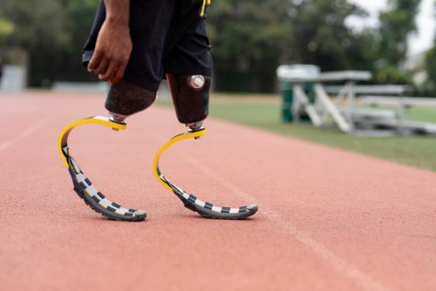 istock Athlete with prosthetic legs on a running track 2157912143