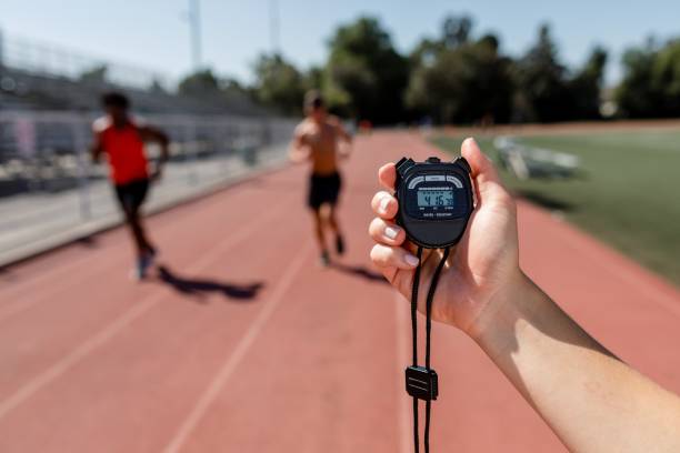 istock Hand holding stopwatch by a running track 2157912285