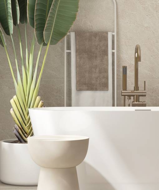 istock Close up of empty brown side table by white bathtub in sunlight from window on beige marble tile wall bathroom with tropical trees 2157913298