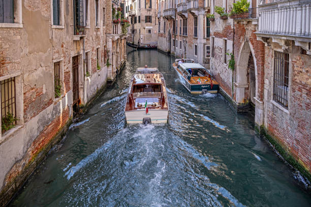 Venice, Italy - June 2nd 2024:  Water taxi in a cannel in Venice. Motorboats are a very popular way of transport in Venice - far more than gondolas - because they are cheaper and faster