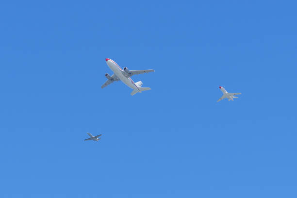 Gijon, Spain - May 24, 2024: Three airplanes fly in formation against a clear blue sky at an air show