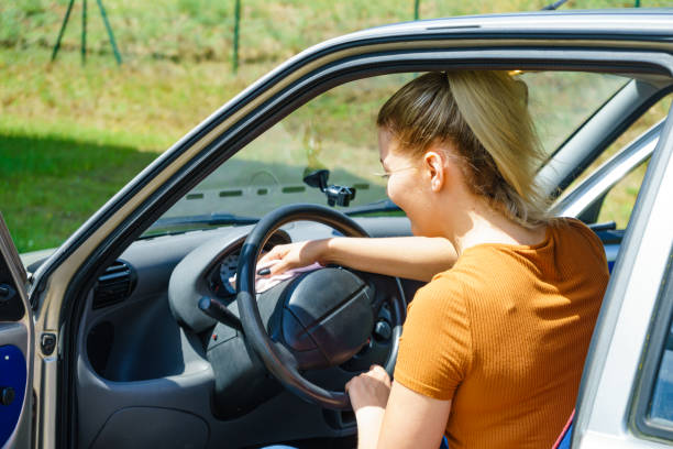 istock Woman cleaning car interior with cloth 2157914573