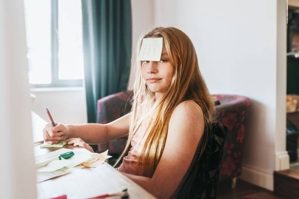 istock Girl with note paper on forehead, homeschooling in the new normal 2157914576