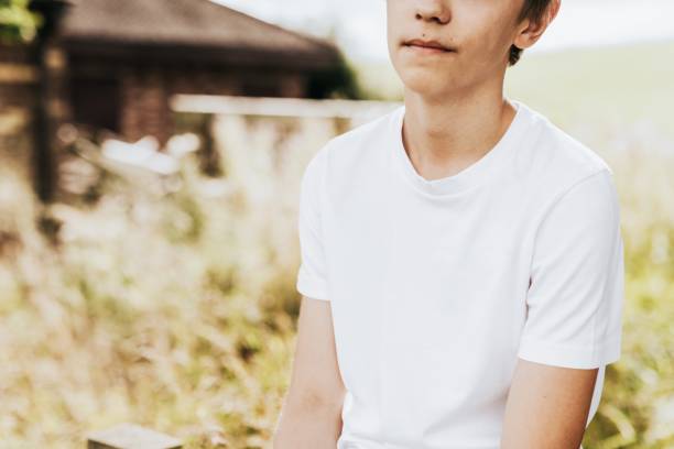 istock Boy in white tee, summer day in a grass field 2157914729