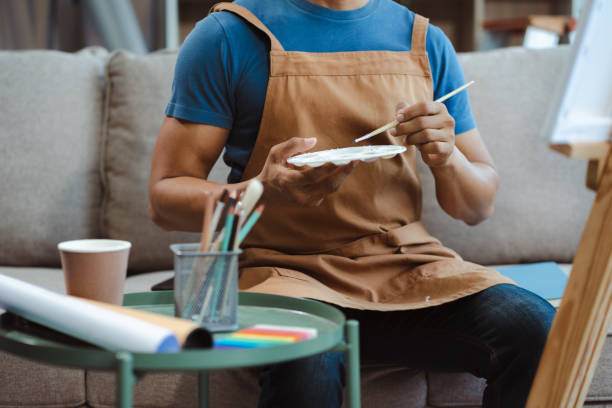 istock Creative painter painting in an art studio. Artistic young man working on a new painting. 2157914763