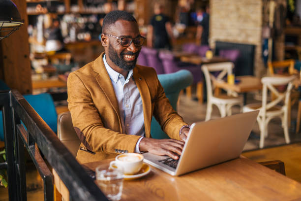 istock an adult handsome black male in cafe using laptop 2157915355