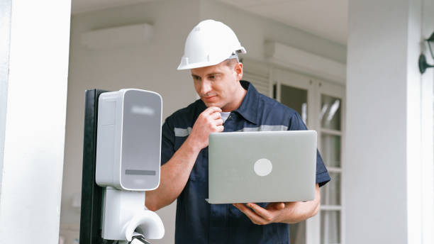 istock Qualified technician working with laptop for home EV station. Synchronos 2157915697