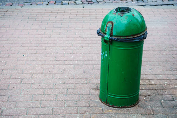 Green pastic garbage bin or can on city street