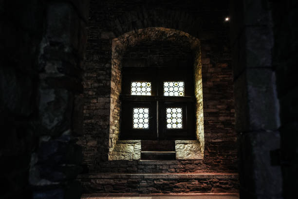 istock Stained Glass Window in a Stone Wall Illuminated by Light 2157916391