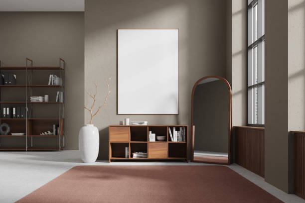 istock A room with a minimalist interior features a blank picture frame, bookshelf, and mirror, light from a large window, modern design, living room concept.  3D Rendering 2157916481