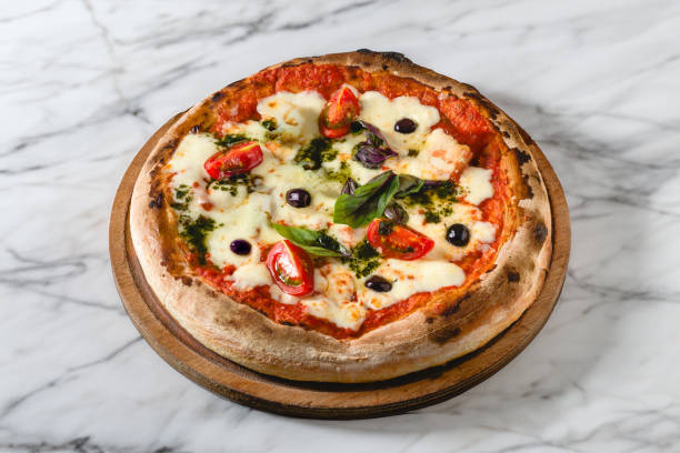 istock Neapolitan pizza with tomatoes, mozzarella, basil and olives on marble table 2157917166