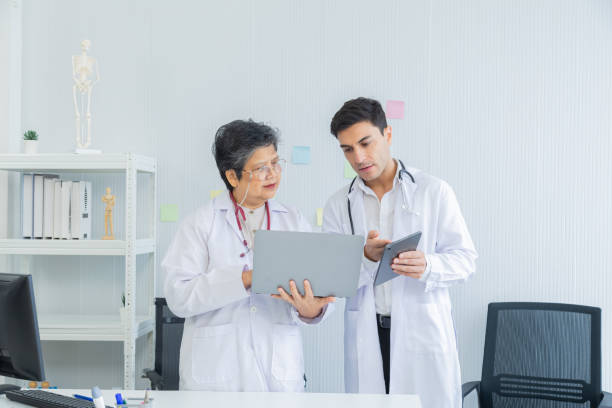 istock Two collaboration doctors team from professional hospital discussing patient information on laptop and tablet. medical office specialist private conference setting in pediatric care with data analysis 2157918704