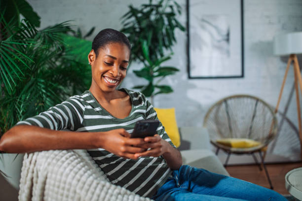 istock Black woman with a smart phone smiling 2157919781