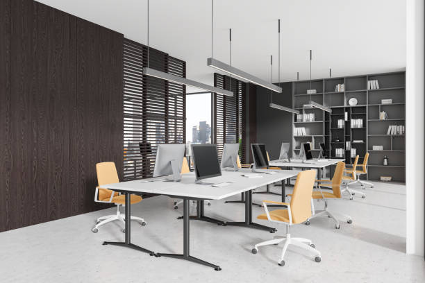 istock Modern coworking interior with pc monitors on desks in row, panoramic window 2157919970