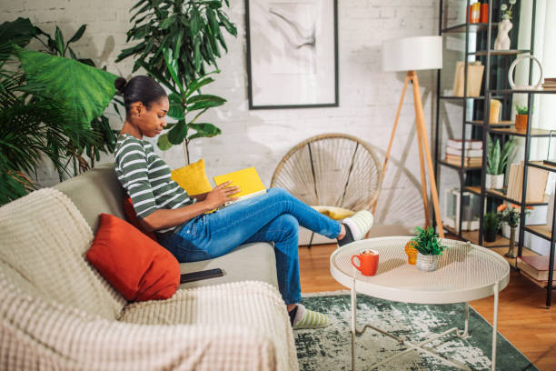 istock Black woman reading a book at home 2157920293