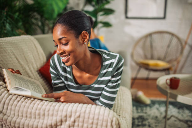 istock Young black woman reading a book in bed 2157920337