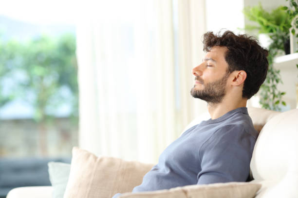 Serious relaxed man breathing at home stock photo