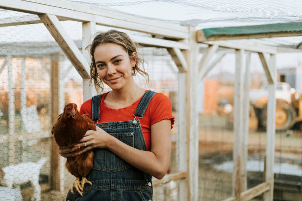 istock Happy young woman with a brown hen 2157921056