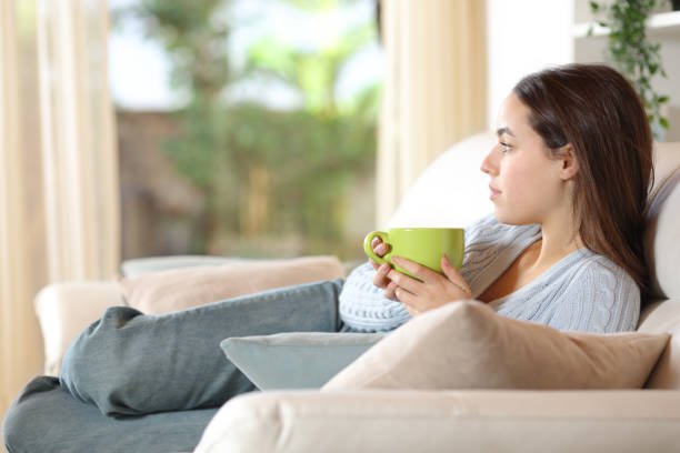 istock Pensive woman relaxing drinking coffee at home 2157921138