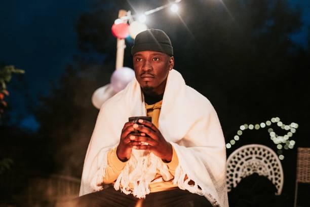 istock Man keeping warm with hot chocolate, a beanie, and a shawl 2157922610