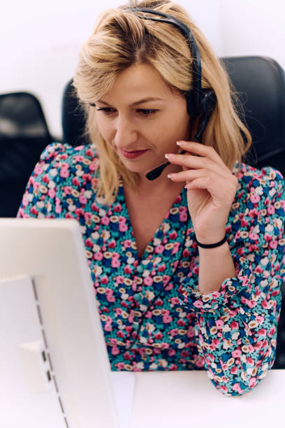 istock Friendly Call Center Agent Answering Incoming Calls with Headset Providing Remote Customer Service. 2157923939