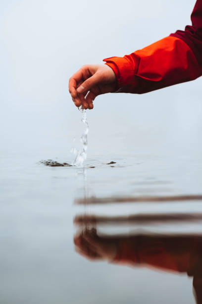 Hand reaching to the water below