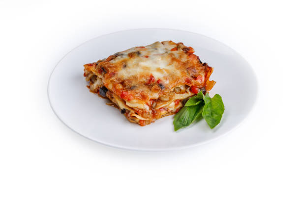 istock plate of lasagna with green basil on white background 2157925838