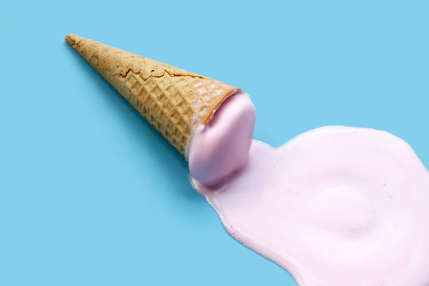 istock Melting ice cream ball with waffle cone on blue background. 2157926323