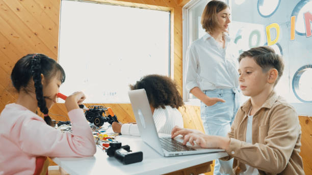 istock Smart teacher teaching and looking student using laptop at classroom. Erudition. 2157928952