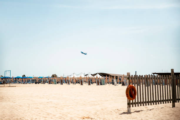 Plane flying over the sand beach on the blue sky. Copy space