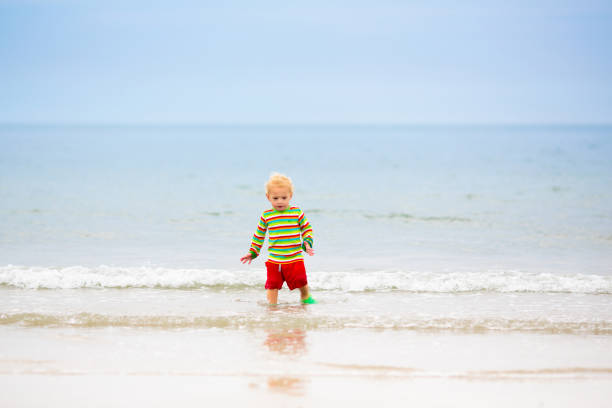 istock Kids playing on beach. Children play at sea. 2157930923