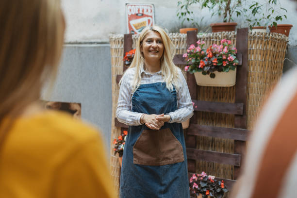 istock Waitress Serving Coffee to Group in Cozy Coffee Bar 2157930983