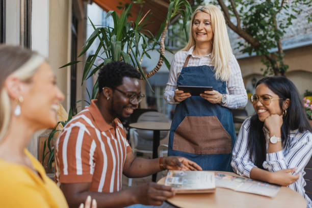 istock Multiracial Group Enjoying Coffee With Friendly Waitress at Cafe 2157930992