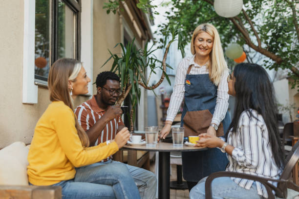 istock Multiracial Friends Enjoying Coffee Served by Waitress at Cafe 2157931032