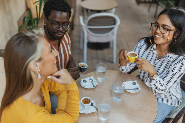 istock Multiracial Friends Enjoying Coffee at a Cozy Coffee Bar 2157931054